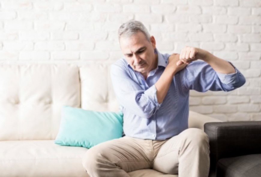 Man holding his shoulder with neck and arm pain from a pinched nerve
