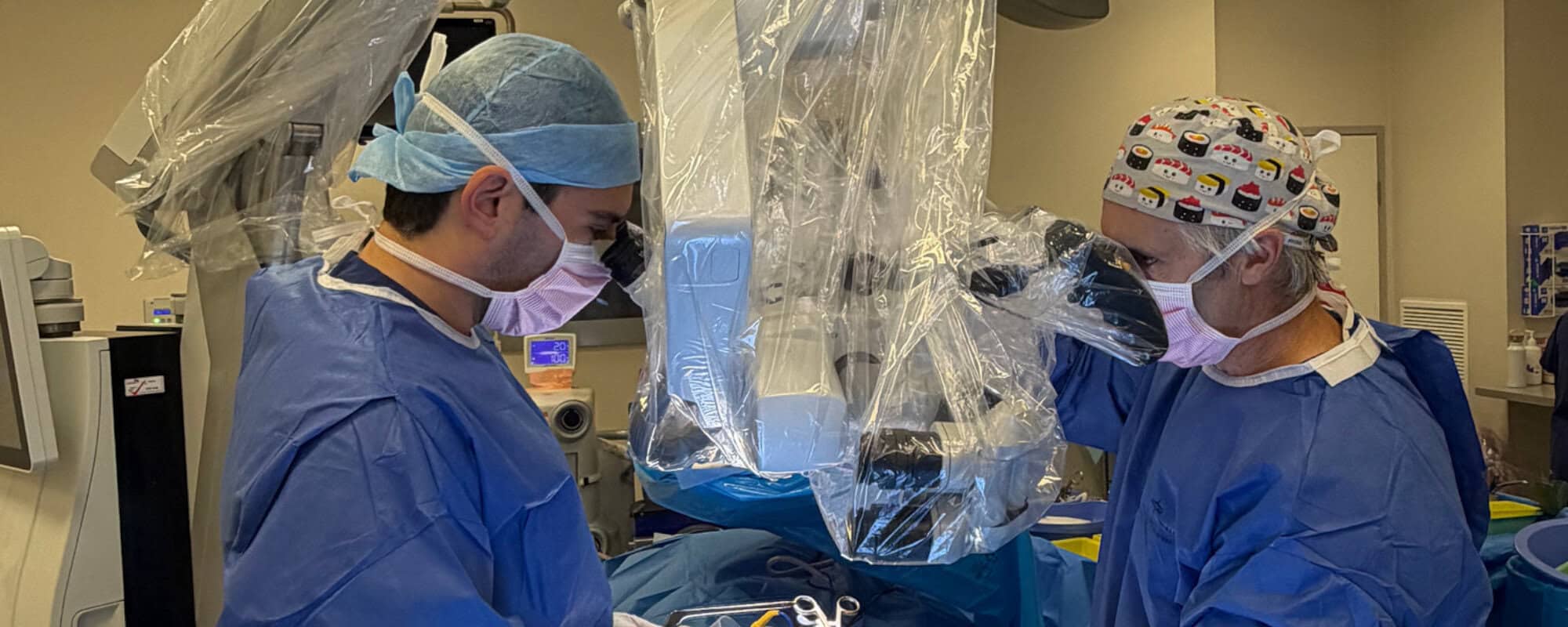 Dr David Edis and surgical team operating under a microscope during spinal fusion surgery