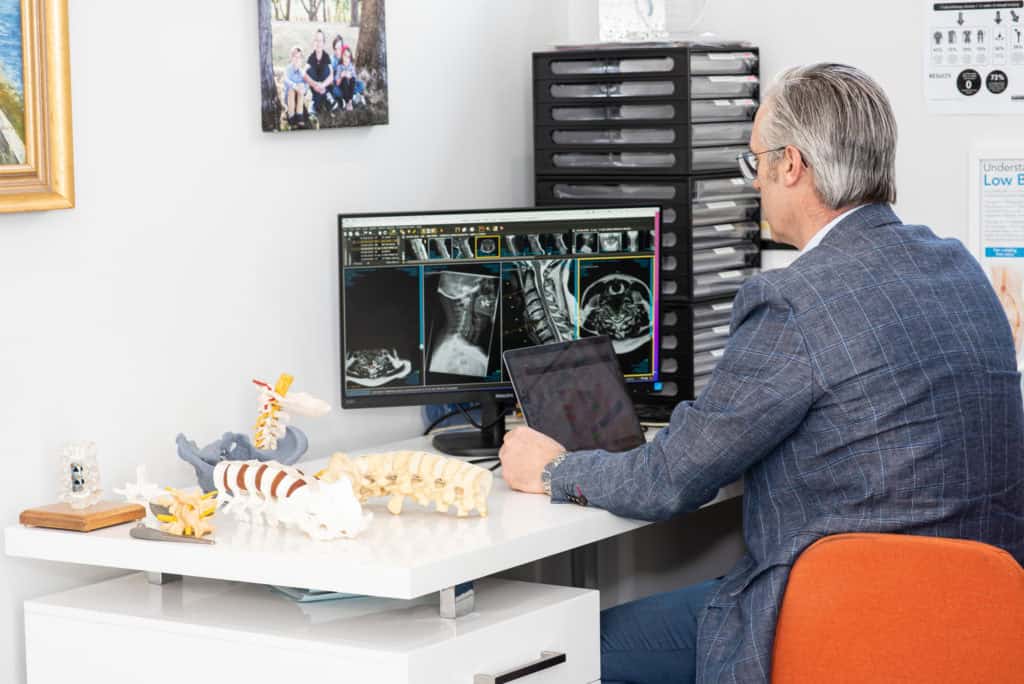Dr David Edis reviewing spine imaging in his consulting room